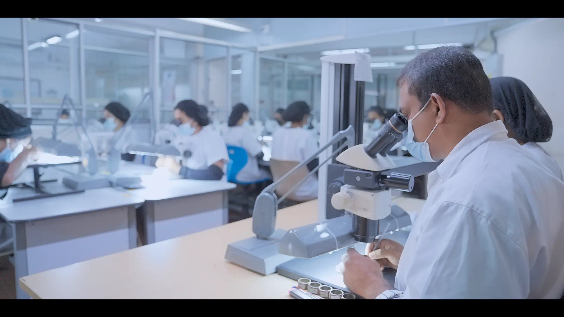 Gemmologist inspecting a diamond under a microscope in the Richold quality control laboratory